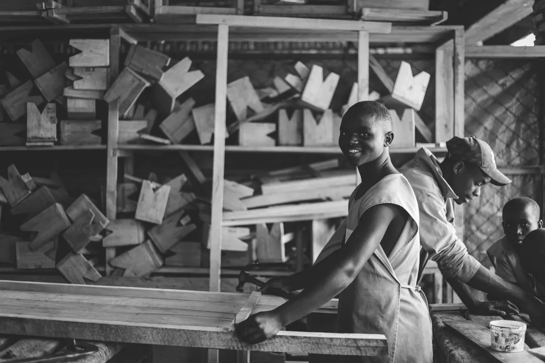 Jeunes apprentis souriants dans un atelier de menuiserie