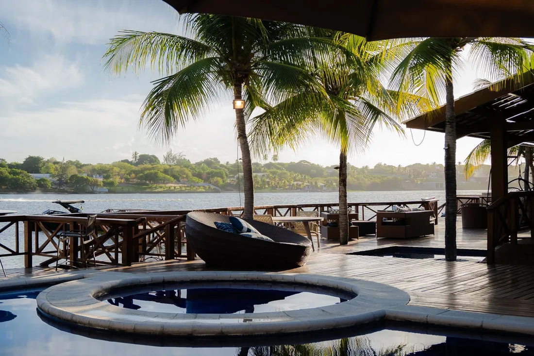 Terrasse tropicale ombragée bordée de palmiers avec vue sur l'océan