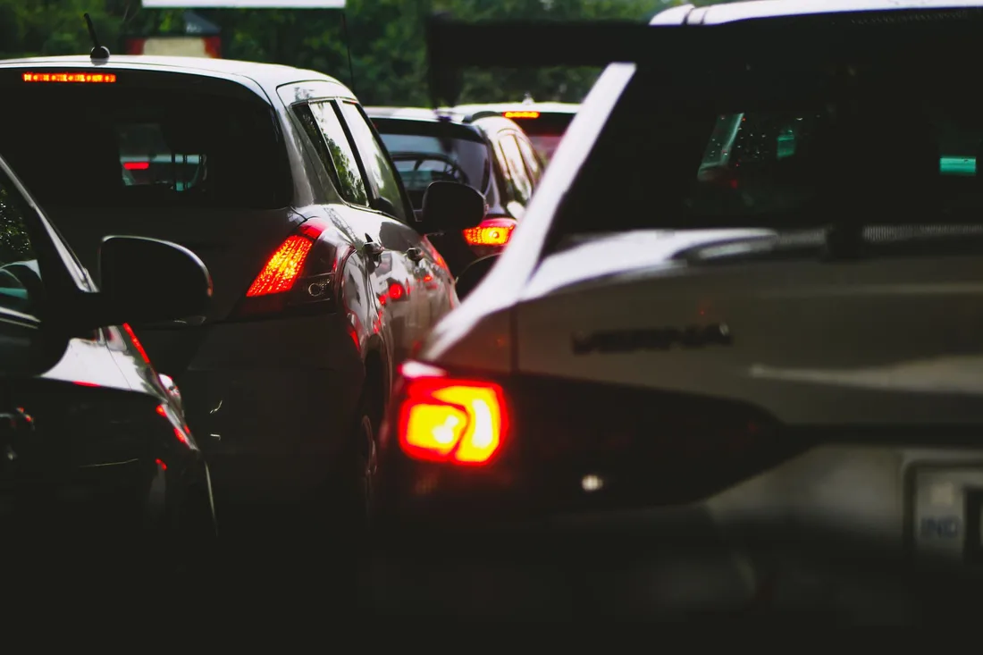 Feux arrière de voitures alignées dans un embouteillage au crépuscule