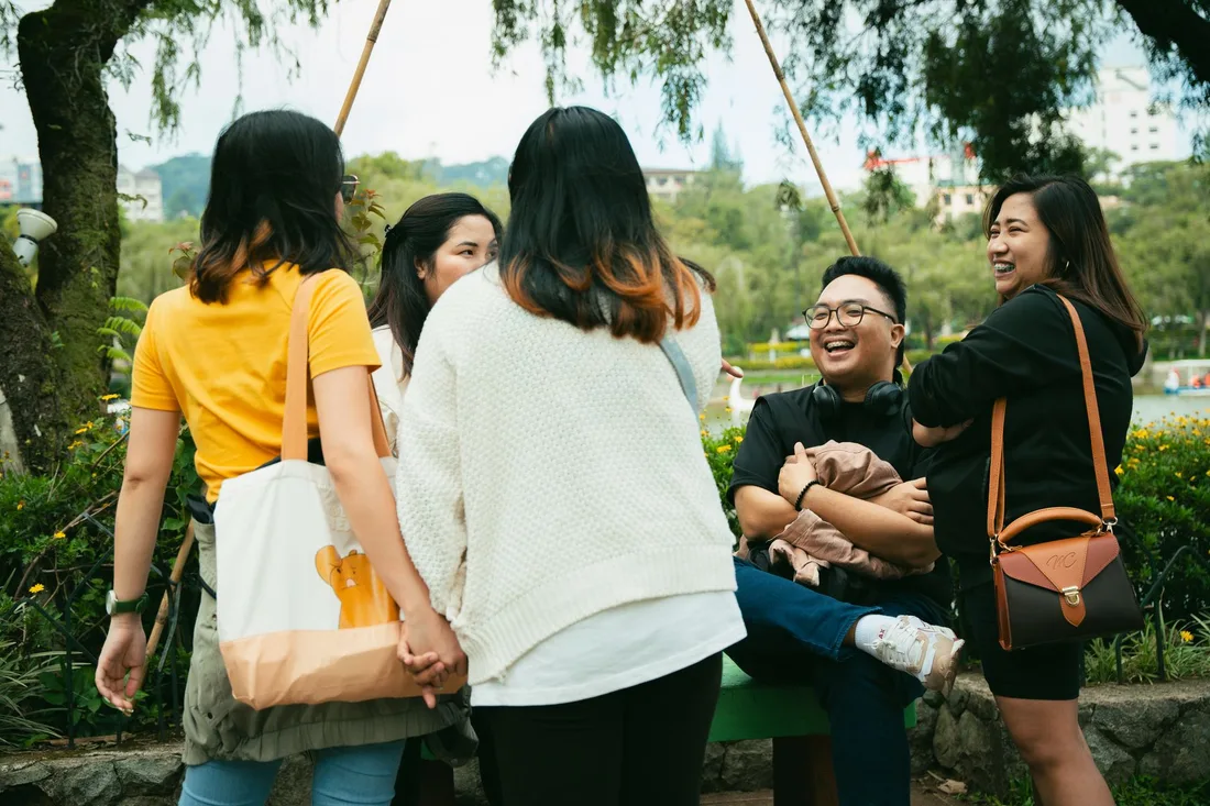 Groupe d'amis discutant dans un parc en pleine journée