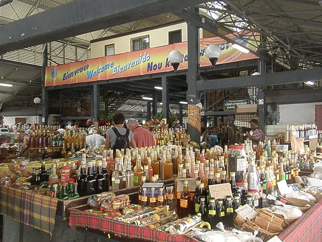Etal d'epices, rhums arranges et produits locaux sur nappe madras au Grand Marche de Fort-de-France en Martinique