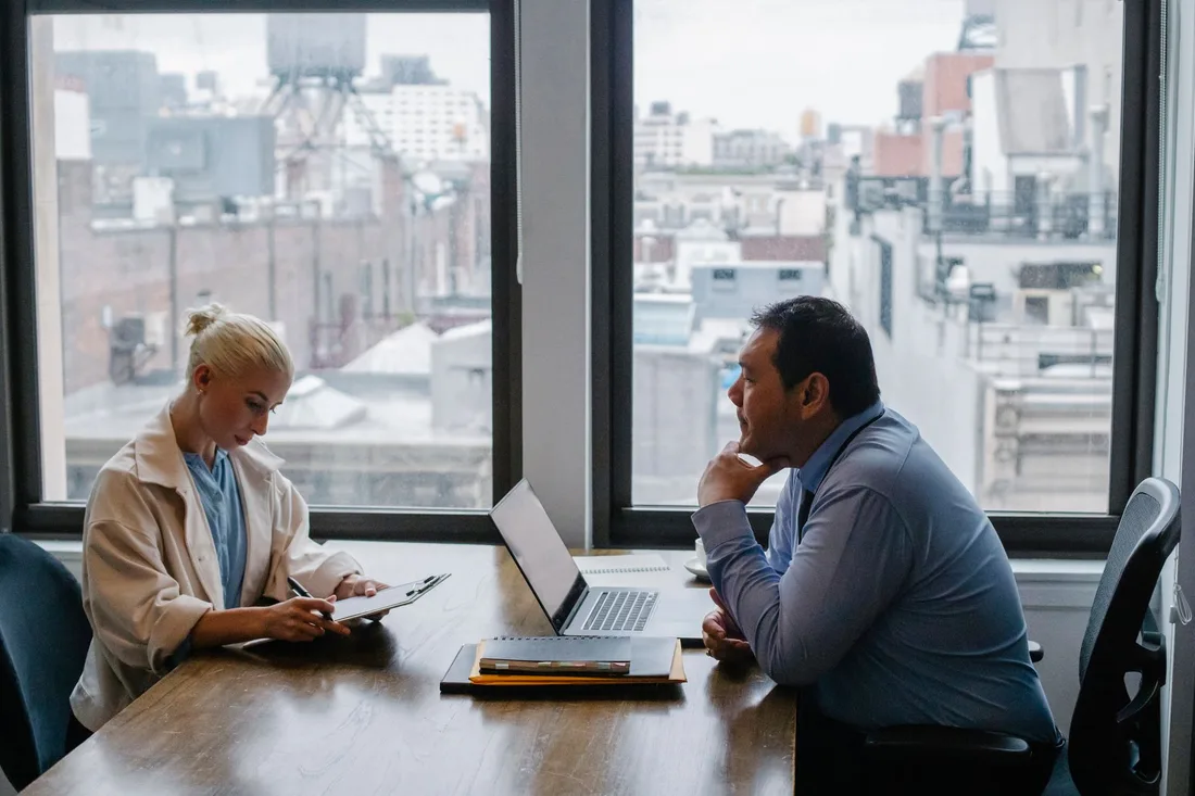 Entretien professionnel entre deux personnes dans un bureau avec vue sur la ville