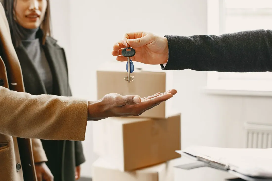 Remise de clés d'un logement devant des cartons de déménagement, emménagement dans un appartement