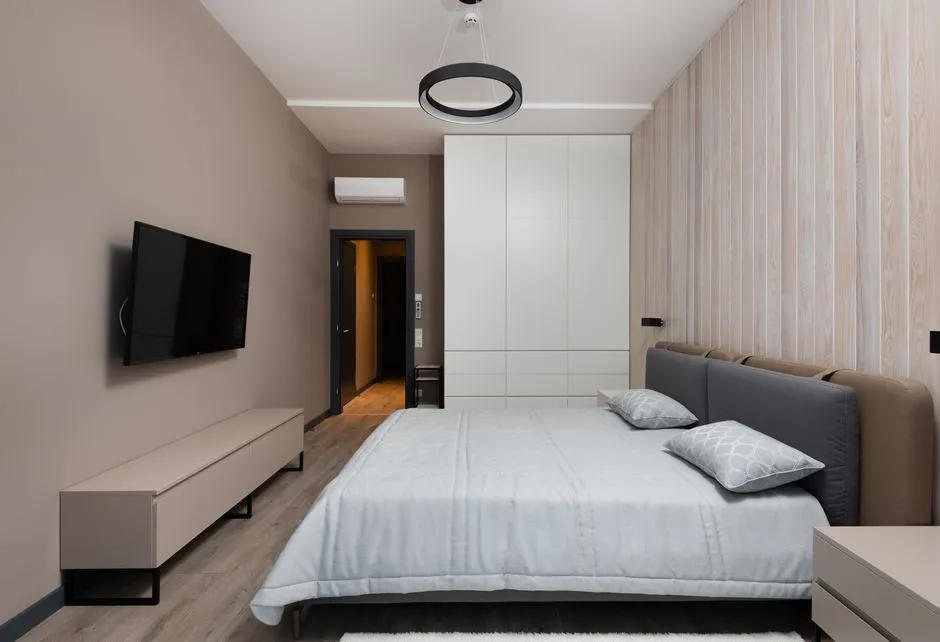 Chambre meublée d'un logement longue durée avec lit double, climatisation, penderie et téléviseur