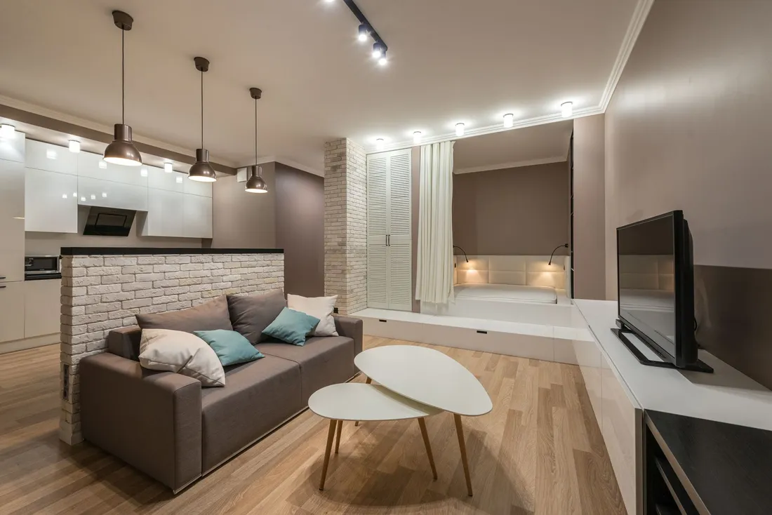 Studio meublé avec kitchenette équipée, canapé, coin nuit et rangements, adapté à un séjour de plusieurs mois