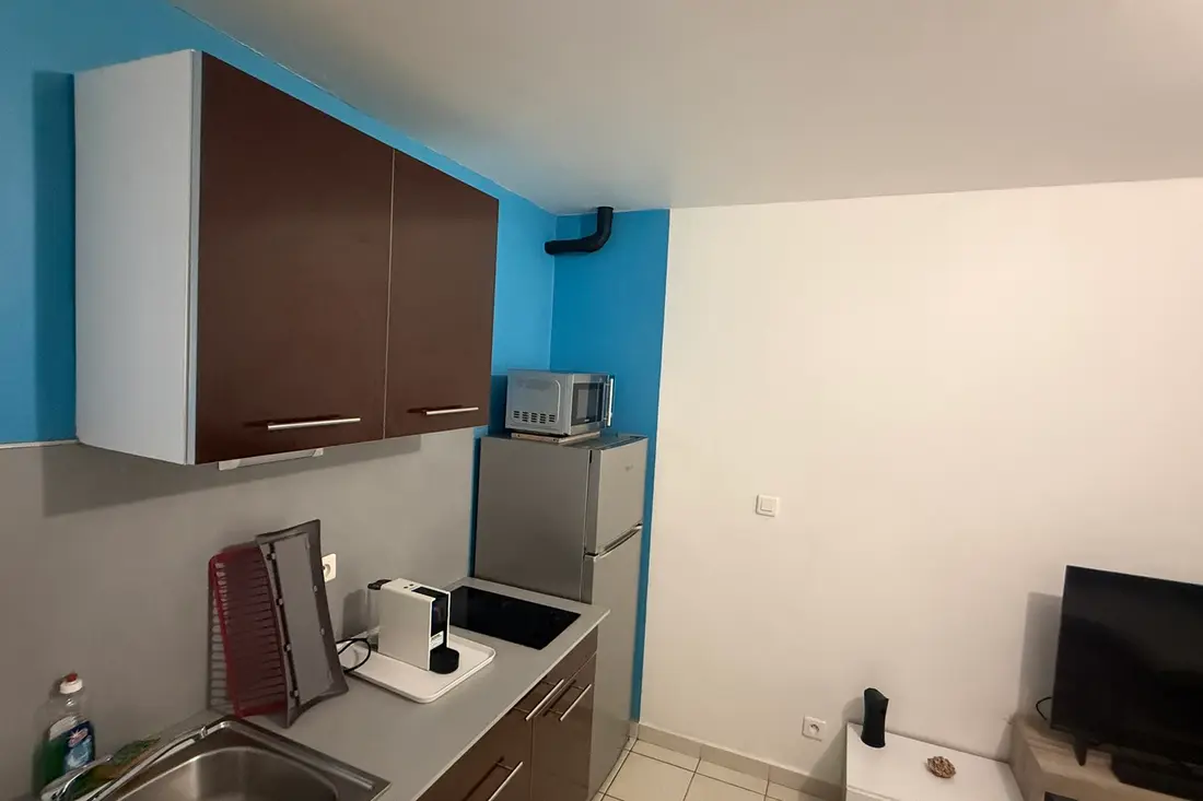 Cozinha equipada do Diamant Cayennais com fogão, micro-ondas e armários