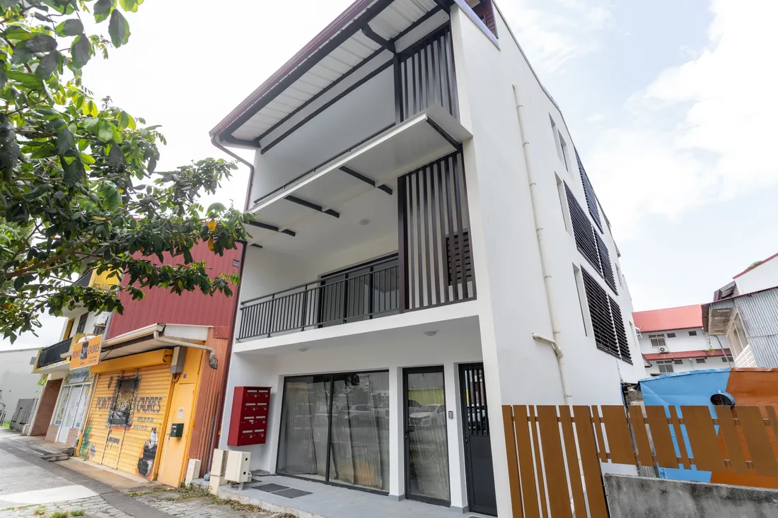 Façade du Nid de Thalys et maisons voisines dans une rue de Cayenne