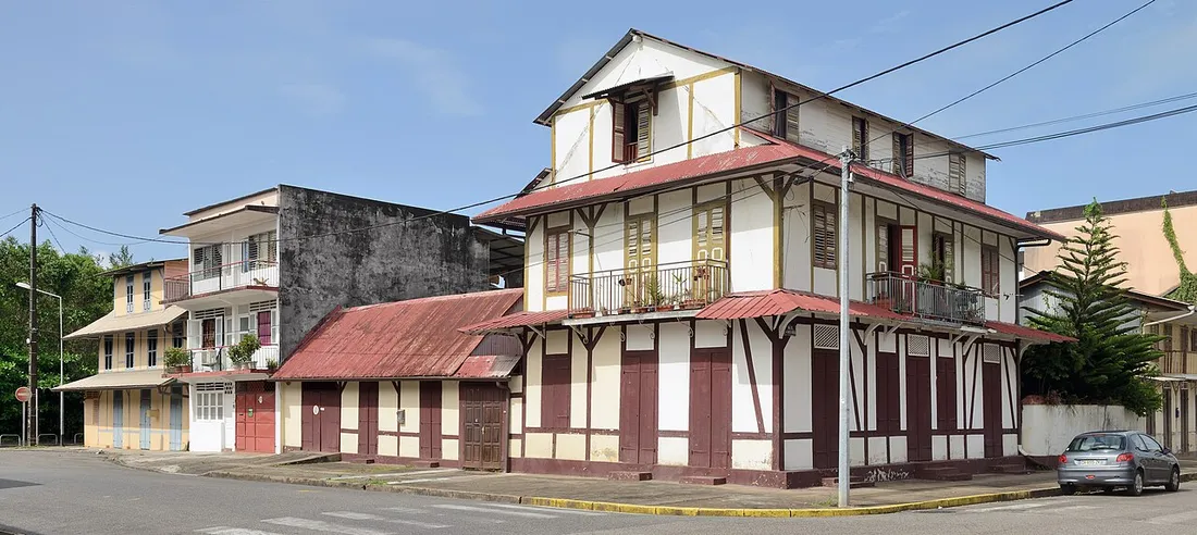 Maisons créoles et petit immeuble de logements à l'angle d'une rue de Cayenne, en Guyane