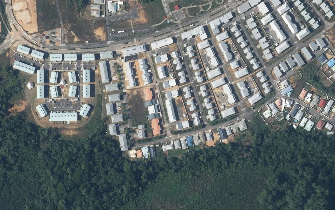 Vue aérienne IGN des Rives de Soula, rue de la Comté, dans la ZAC de Soula à Macouria en Guyane : petits collectifs et maisons de ville alignés