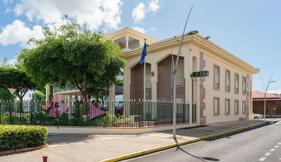 Hôtel de ville de Baie-Mahault en Guadeloupe, bâtiment administratif avec drapeaux, cadre des démarches et paiements par virement entreprise sur l'île