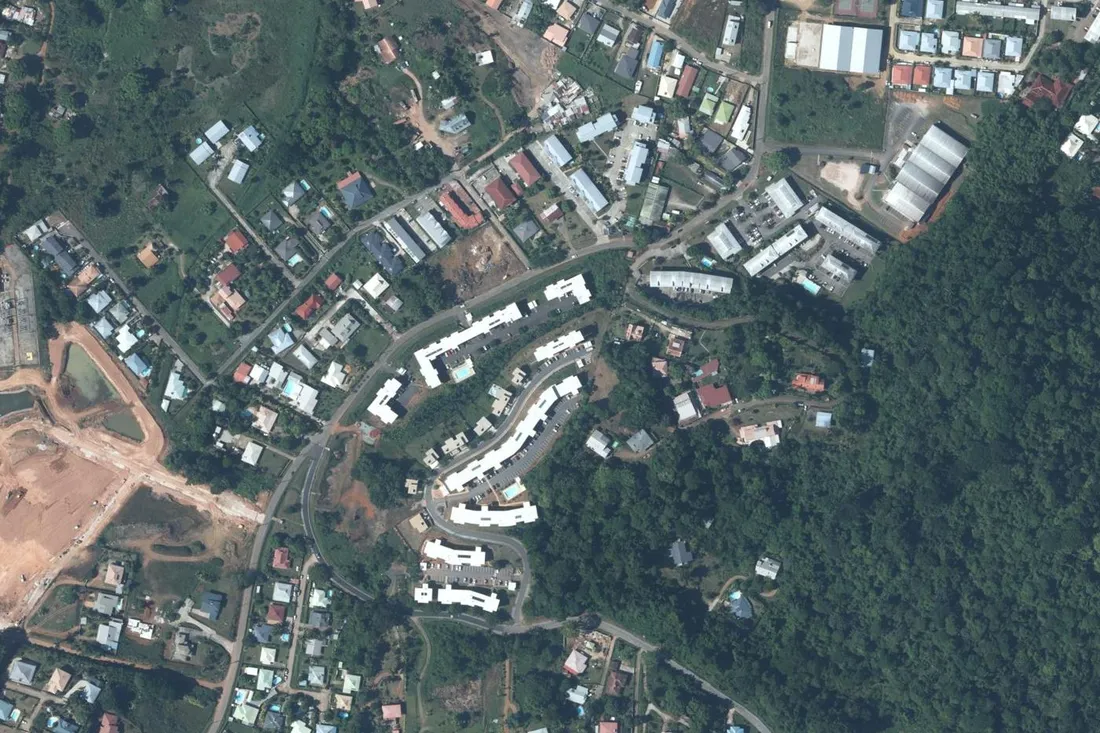 Orthophotographie aérienne d'un ensemble de petits immeubles collectifs blancs bordant la rue de l'Horizon, en retrait de la route de Suzini, à Rémire-Montjoly.