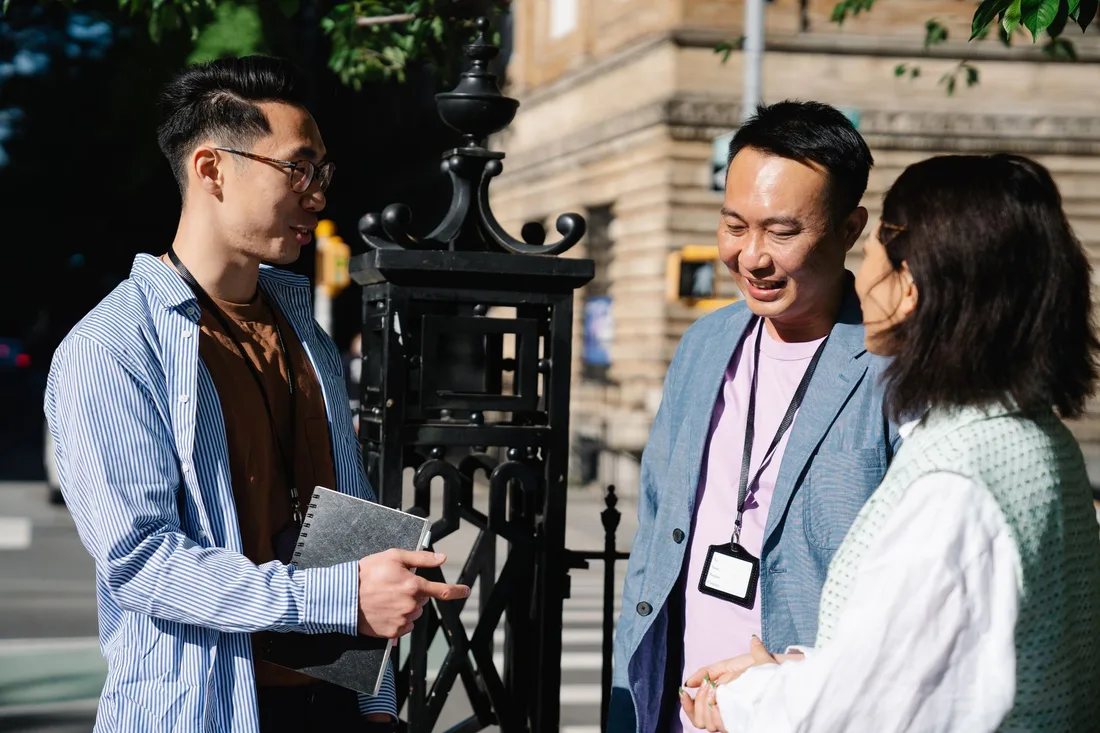 Groupe de collègues en discussion professionnelle à l'extérieur par temps ensoleillé