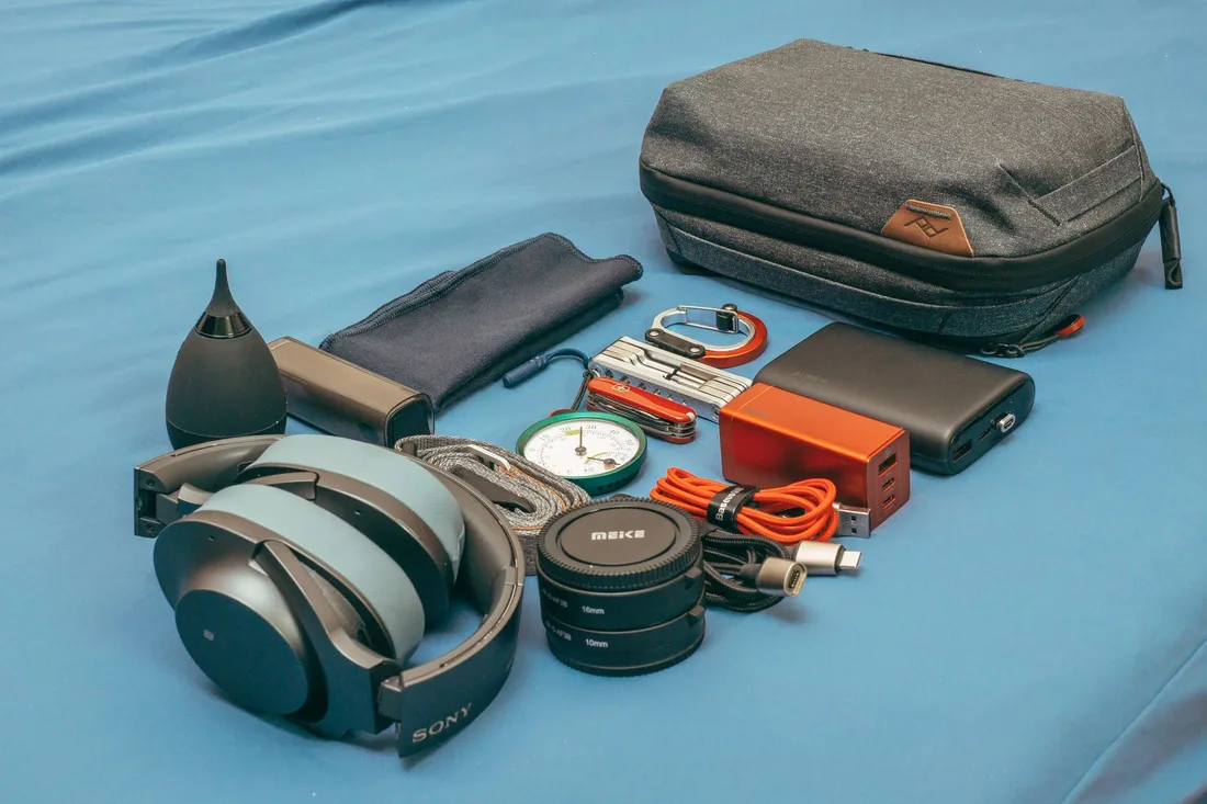Équipement de voyage disposé à plat : batterie externe, boussole, accessoires