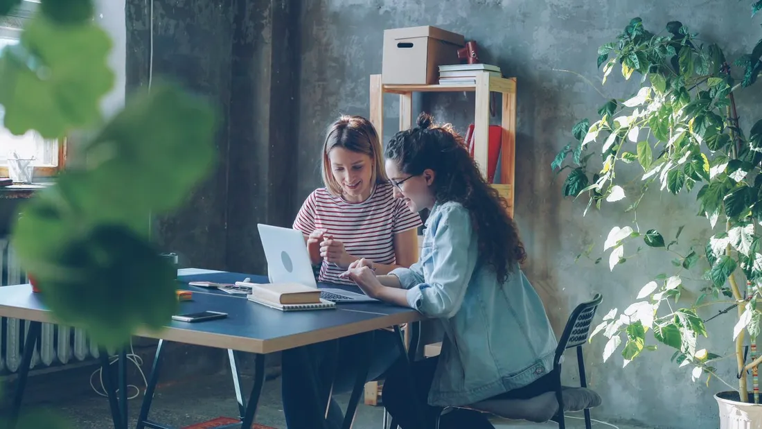 Deux personnes planifiant ensemble sur un ordinateur portable, ambiance de reservation simple et collaborative