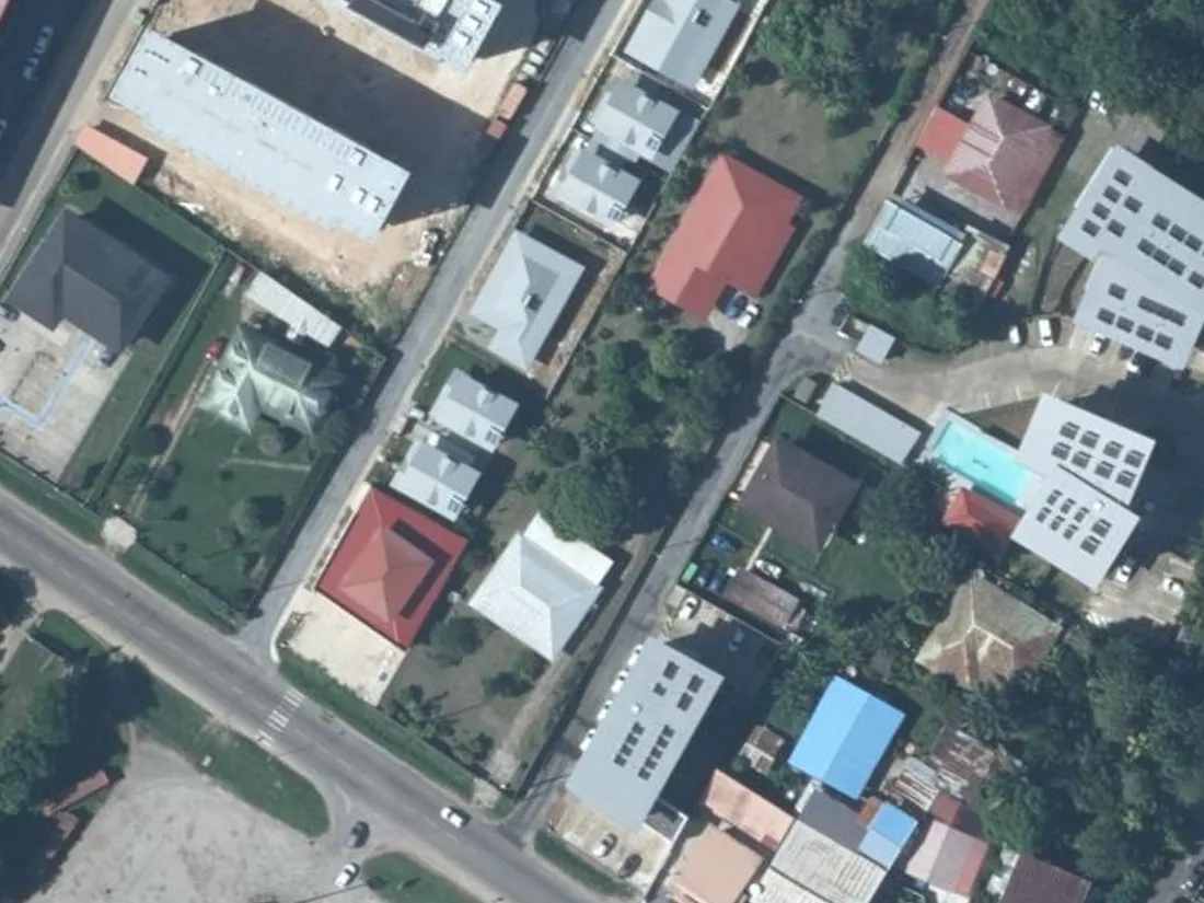 Vue aérienne verticale de l'impasse Saramaka à Cayenne, en Guyane, greffée sur la route de Baduel, avec le petit immeuble collectif du Clos de Baduel et les maisons voisines