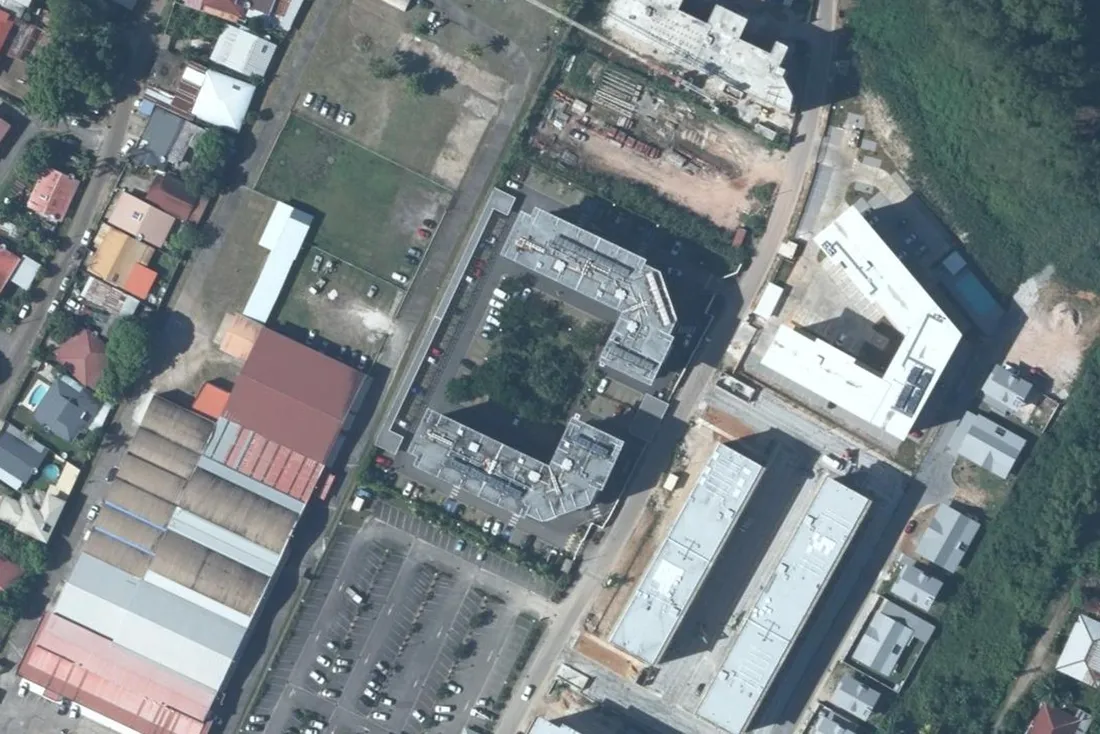 Vue aérienne de l'îlot du 3 rue de l'Union à Cayenne, avec les deux bâtiments de la résidence Les Terrasses de Baduel, la rue de l'Union et les parkings voisins