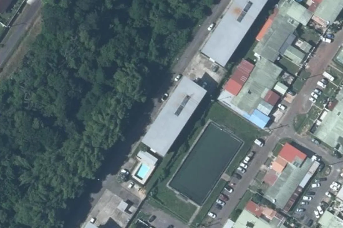 Vue aérienne IGN du 1400 route de Montabo à Cayenne : bâtiment en barre, piscine et plateau sportif de la résidence, parcelle AT 407