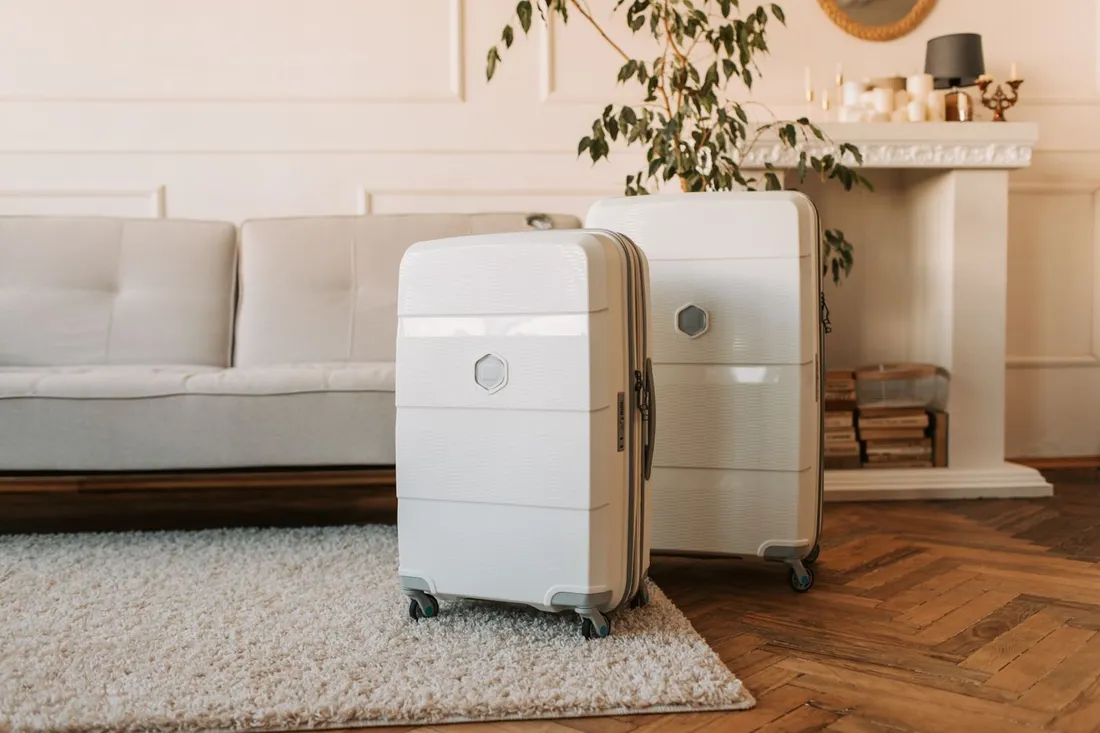 Deux valises rigides posees dans le salon meuble d'un appartement, pretes pour une installation longue duree en Guadeloupe