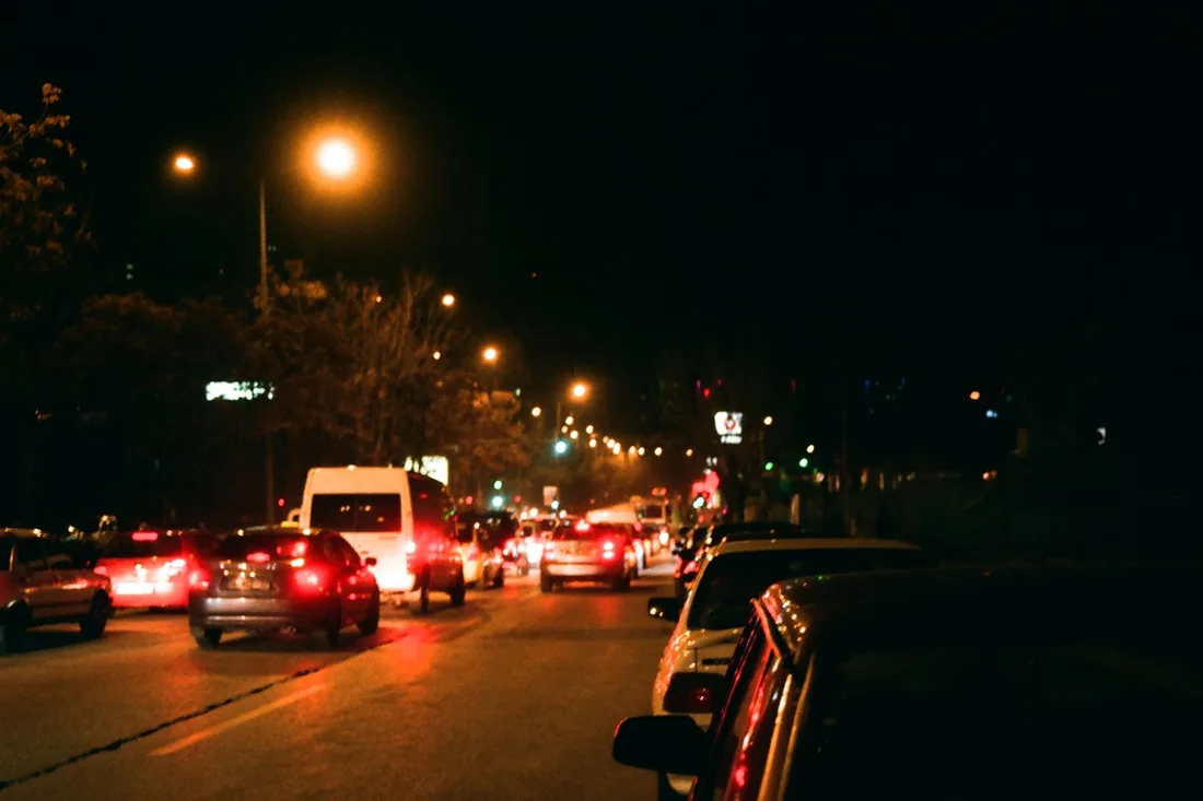 Rue urbaine éclairée la nuit, circulation et lampadaires