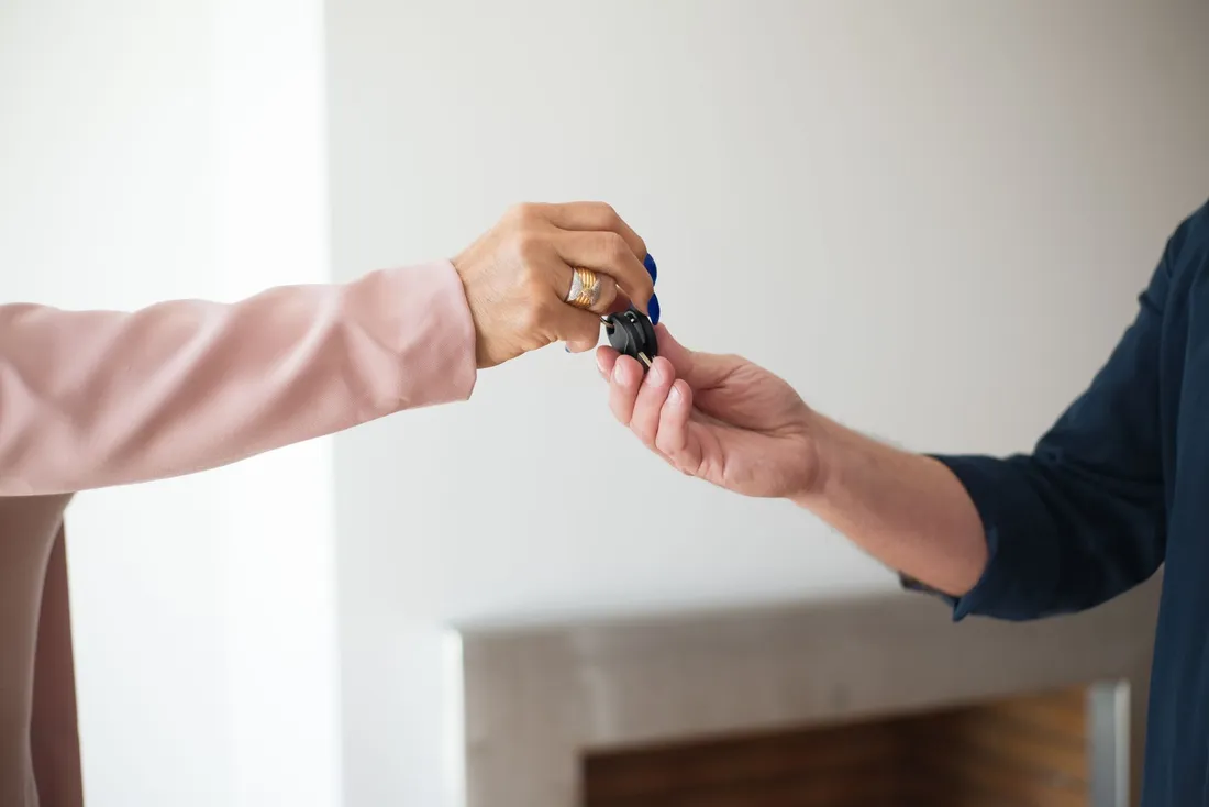 Remise des clés d'un appartement d'une main à une autre dans un logement lumineux