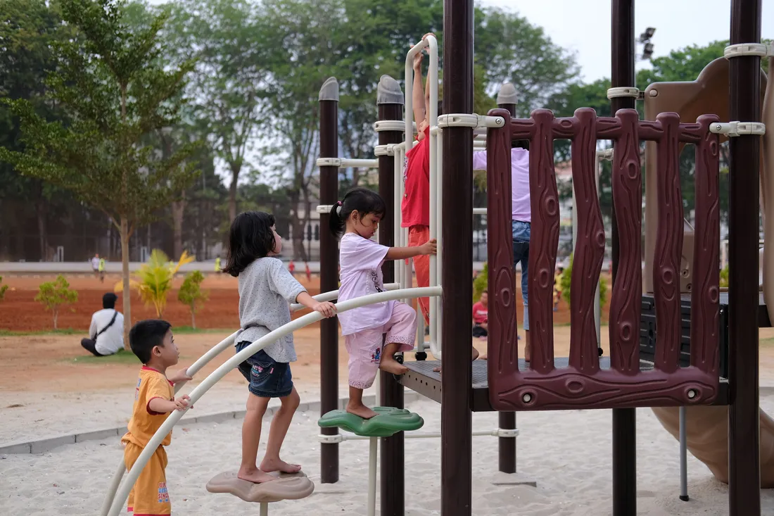 Enfants qui grimpent et jouent sur une structure de jeux dans une aire de jeux en plein air d'un parc